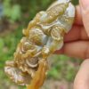 Una mano sosteniendo un colgante de jade.