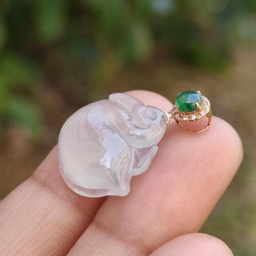 a hand holding a jade pendant