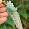 Una mano sosteniendo un colgante de jade.