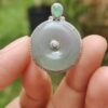 Una mano sosteniendo un colgante de jade.