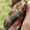 a hand holding a jade pendant