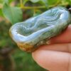 a hand holding a green stone