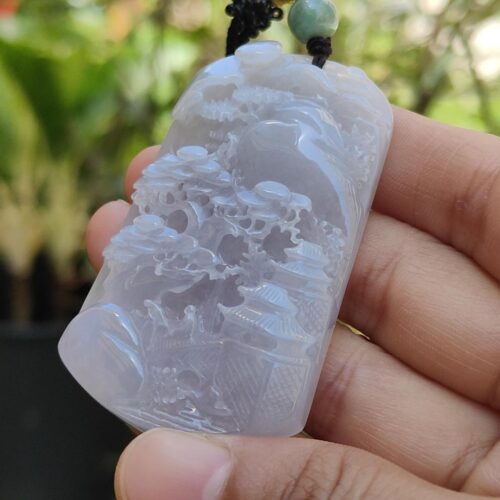 Una mano sosteniendo un colgante de jade.