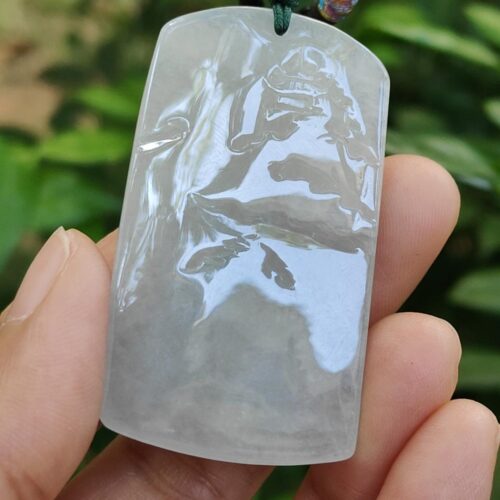 a hand holding a jade pendant