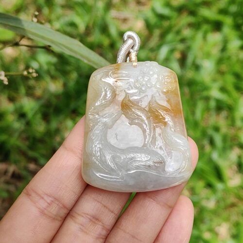 Una mano sosteniendo un colgante de jade.