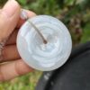 a hand holding a white round object