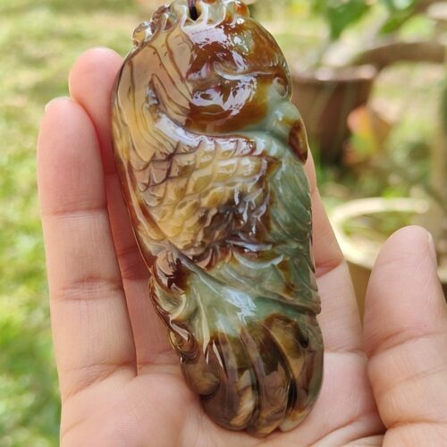 a hand holding a stone pendant