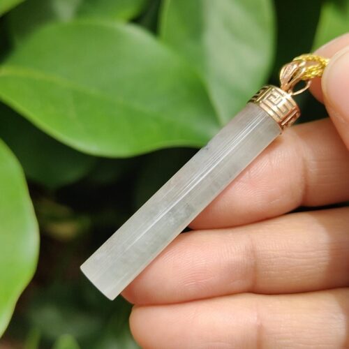 Una mano sosteniendo un colgante de jade.