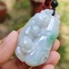 a hand holding a jade pendant