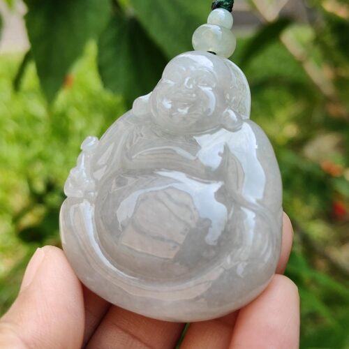 Una mano sosteniendo un colgante de jade.