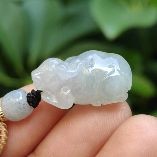 a hand holding a jade bead