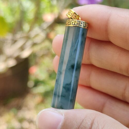 uma mão segurando um pingente de jade