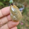 Una mano sosteniendo un colgante de jade.