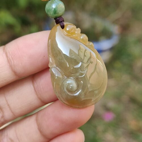 Una mano sosteniendo un colgante de jade.