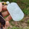 Una mano sosteniendo un colgante de jade.