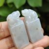 a hand holding a pair of carved white stones