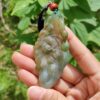 Una mano sosteniendo un colgante de jade.