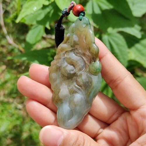 Una mano sosteniendo un colgante de jade.