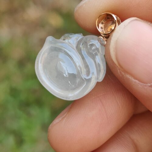 a hand holding a clear plastic pendant
