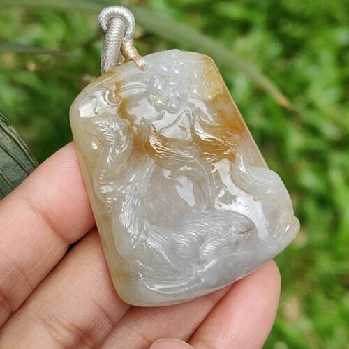 Una mano sosteniendo un colgante de jade.