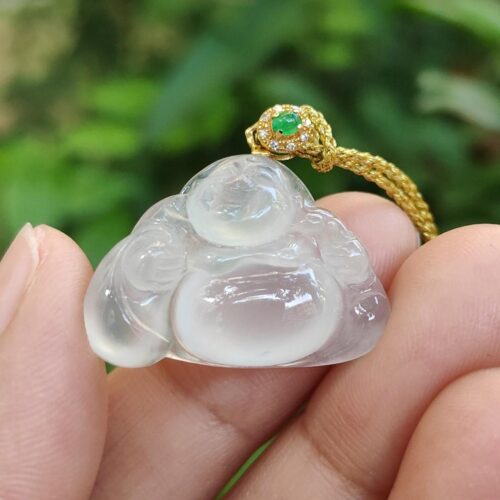 a hand holding a jade pendant