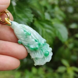 Una mano sosteniendo un colgante de jade.