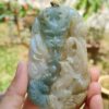 a hand holding a jade pendant