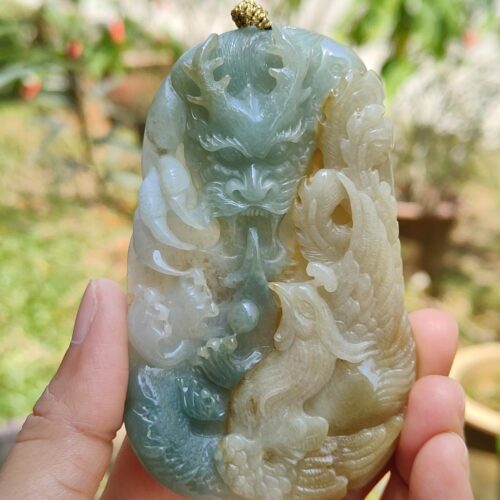 a hand holding a jade pendant