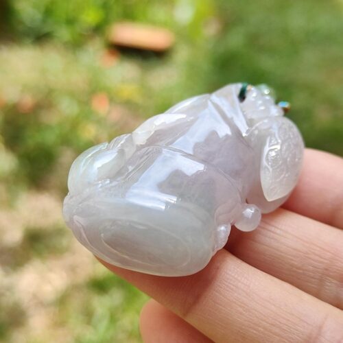 a hand holding a white frog