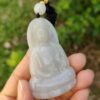 Una mano sosteniendo un colgante de jade.