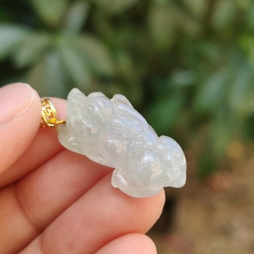 Una mano sosteniendo un colgante de jade.