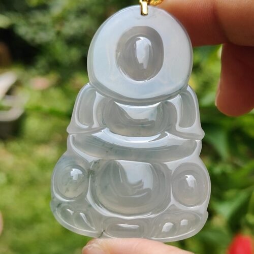 a hand holding a jade pendant
