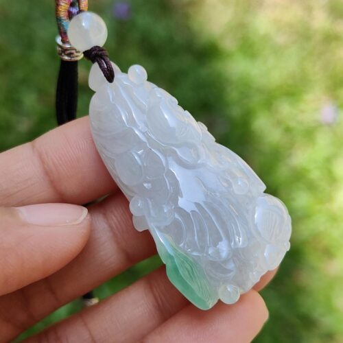 Una mano sosteniendo un colgante de jade.