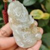 a hand holding a jade pendant