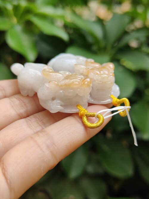 Una mano que sostiene un pequeño animal de piedra blanca.