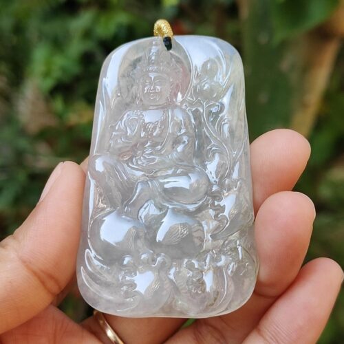 a hand holding a jade pendant