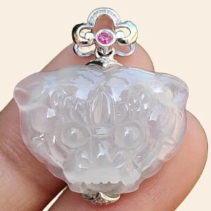 a hand holding a white jade pendant