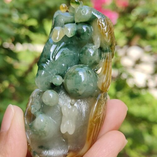 a hand holding a jade sculpture
