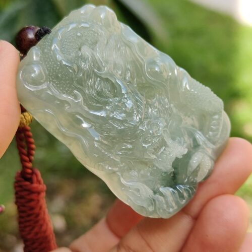 Una mano sosteniendo un colgante de jade.