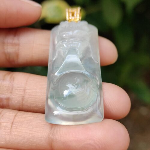 a hand holding a jade pendant