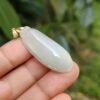 Una mano sosteniendo un colgante de jade.