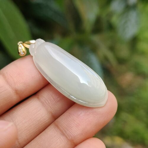 Una mano sosteniendo un colgante de jade.