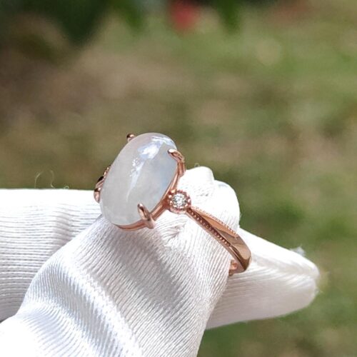 a hand wearing a white glove with a ring on it