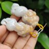 a hand holding a small white and yellow stone