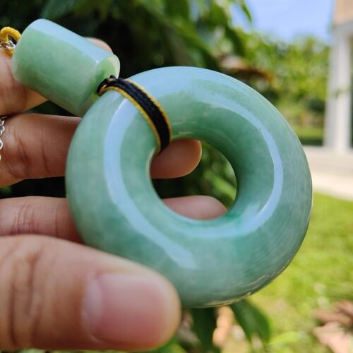 a hand holding a jade necklace
