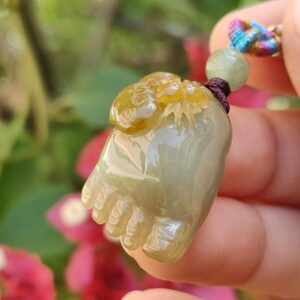 Una mano sosteniendo un colgante de jade.