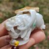 a hand holding a small white stone animal