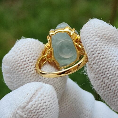 a hand wearing gloves holding a gold ring