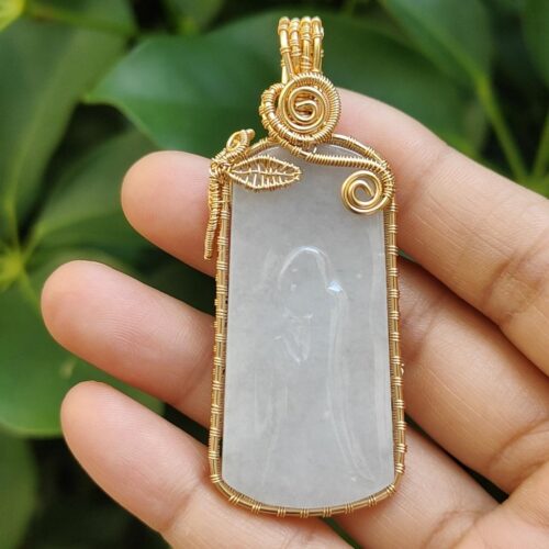 एक हाथ में पेंडेंट पकड़े हुए