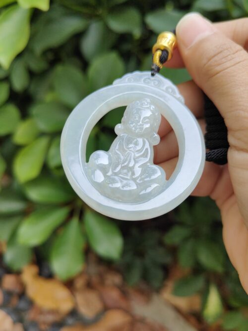 a hand holding a jade pendant